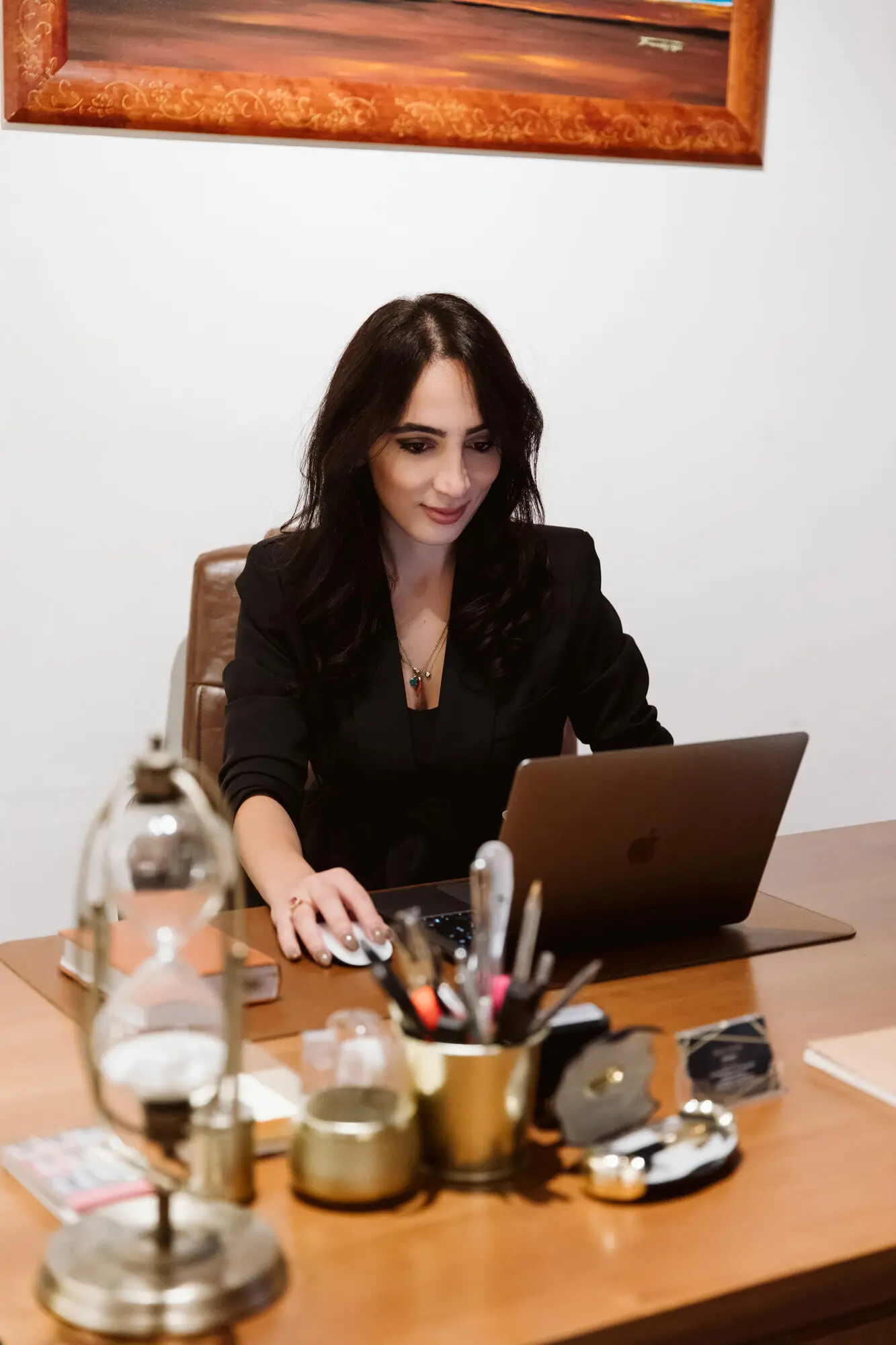 Ada Alia al lavoro alla scrivania dello studio, in giacca nera
